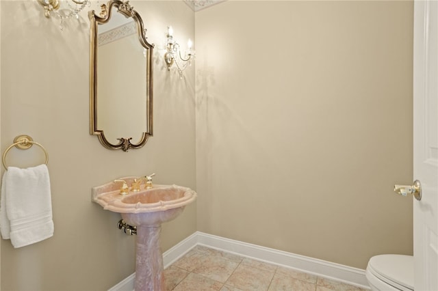 bathroom featuring baseboards and toilet