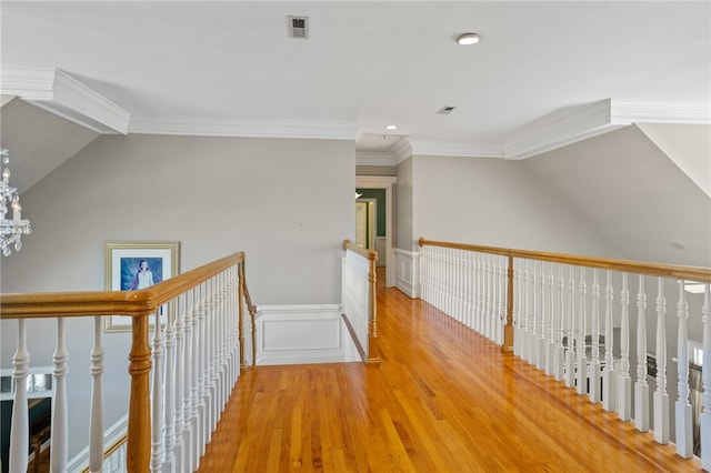 hall with a wainscoted wall, recessed lighting, an upstairs landing, wood finished floors, and lofted ceiling
