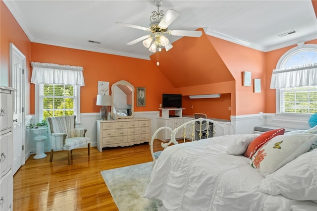 bedroom with crown molding, wainscoting, visible vents, and multiple windows