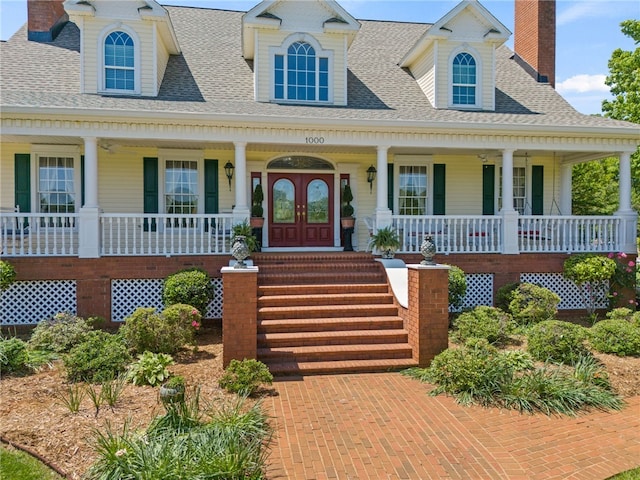 view of front of house with a shingled roof, covered porch, and a chimney