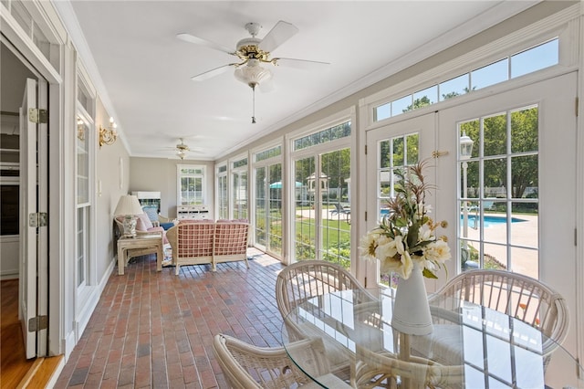 sunroom featuring french doors, plenty of natural light, and a ceiling fan