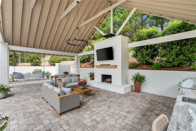 view of patio with an outdoor brick fireplace and a gazebo
