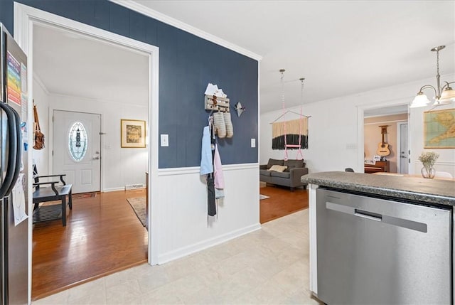 kitchen with stainless steel dishwasher, freestanding refrigerator, crown molding, and hanging light fixtures