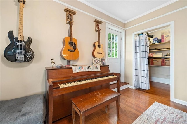 living area featuring baseboards, ornamental molding, and wood finished floors