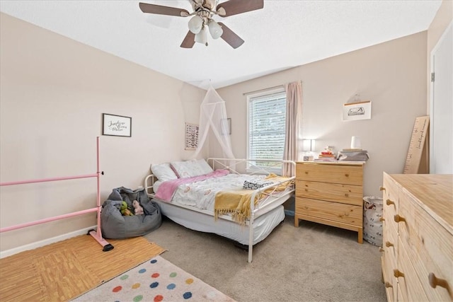 bedroom featuring light colored carpet, baseboards, and ceiling fan