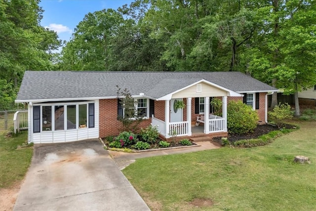 ranch-style house featuring a front lawn, brick siding, a shingled roof, concrete driveway, and a porch
