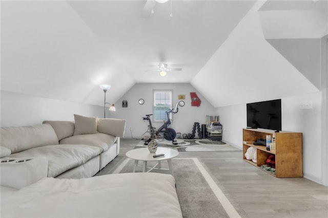 living area featuring ceiling fan, wood finished floors, and vaulted ceiling