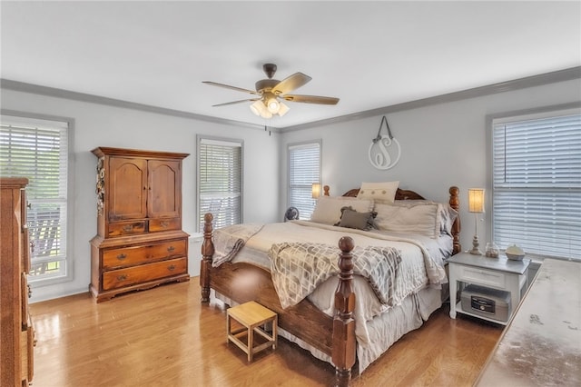 bedroom featuring crown molding, a ceiling fan, and light wood-style flooring