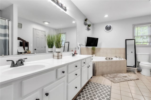 full bath featuring a sink, tile patterned flooring, double vanity, toilet, and a garden tub