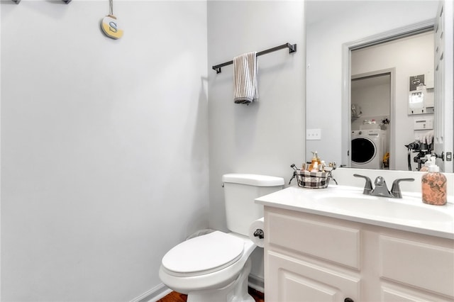 bathroom featuring vanity, washer / clothes dryer, and toilet