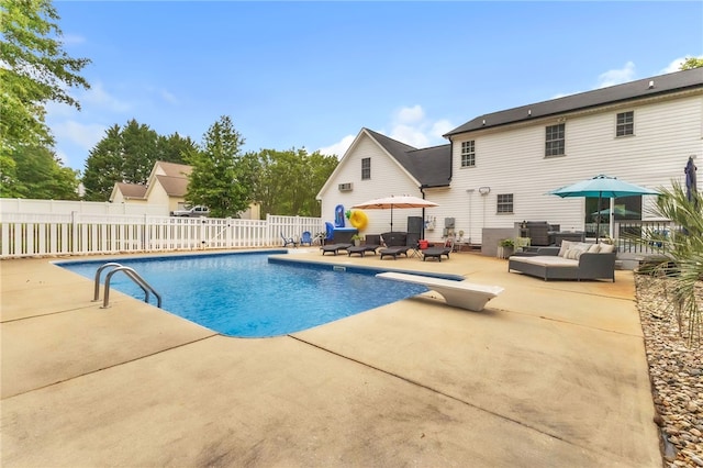 view of pool with fence, a diving board, a fenced in pool, an outdoor living space, and a patio