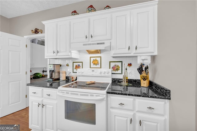 kitchen with white cabinets, dark stone counters, decorative backsplash, under cabinet range hood, and white electric range