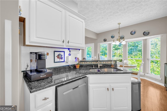kitchen with stainless steel dishwasher, a sink, white cabinets, a peninsula, and light wood-style flooring