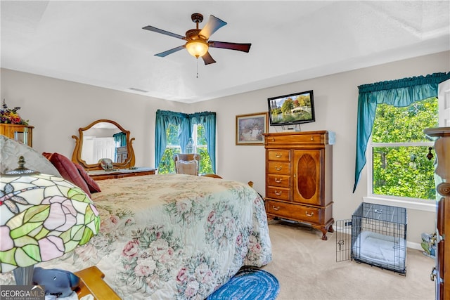 carpeted bedroom featuring a ceiling fan and visible vents