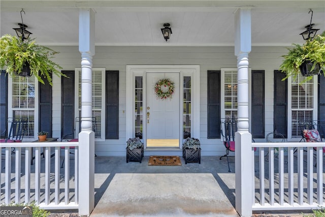 property entrance featuring covered porch and brick siding