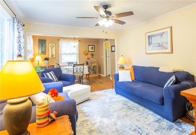 living room with baseboards, ceiling fan, ornamental molding, and wood finished floors
