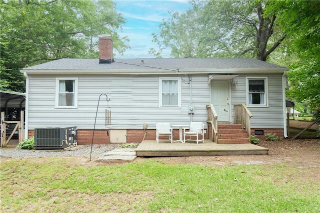 back of house featuring a yard, central AC, a chimney, and a wooden deck