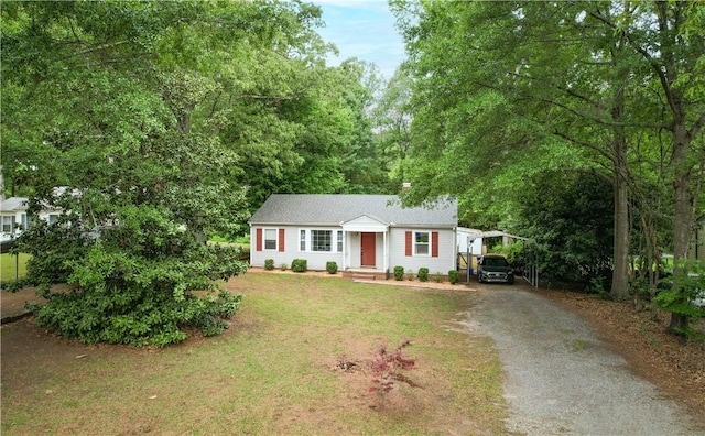 ranch-style home featuring a carport, driveway, and a front lawn