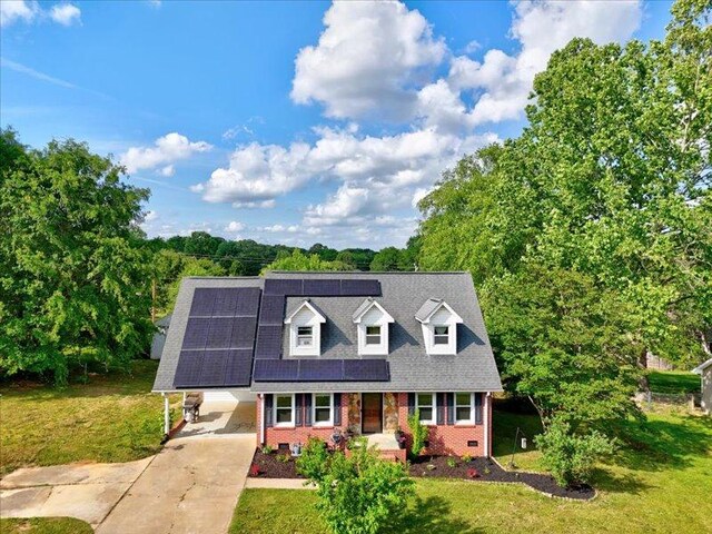 415 Van Martin Rd, Anderson, SC 29621 - cape cod home featuring a front yard, an attached carport, brick siding, driveway, and solar panels