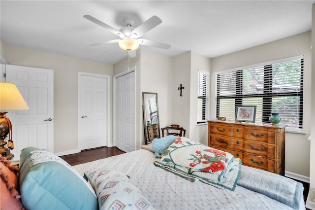 bedroom with baseboards, ceiling fan, wood finished floors, and a closet