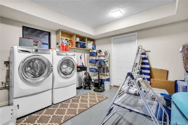 laundry area with laundry area, a textured ceiling, and washer and dryer