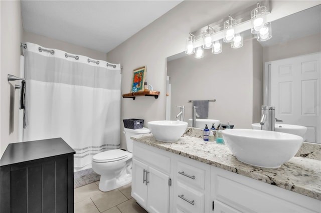 full bath featuring double vanity, a sink, tile patterned floors, and toilet