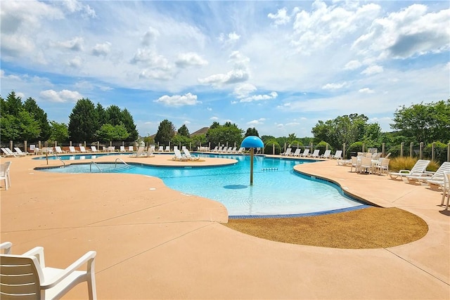 pool with a patio and fence