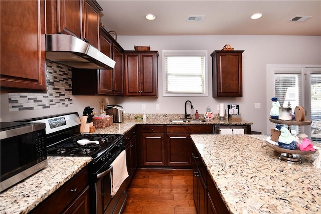 kitchen featuring visible vents, a sink, under cabinet range hood, and stainless steel appliances
