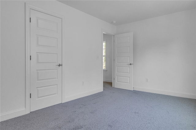 unfurnished bedroom with carpet floors and baseboards