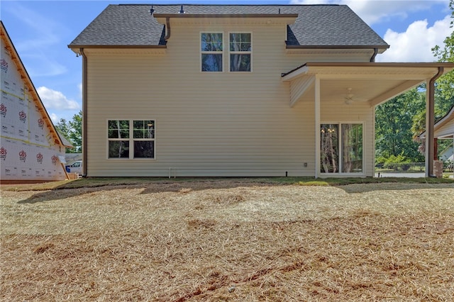 back of house with a shingled roof and ceiling fan