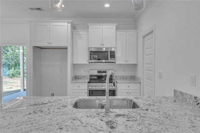 kitchen featuring visible vents, crown molding, light stone countertops, white cabinets, and stainless steel appliances