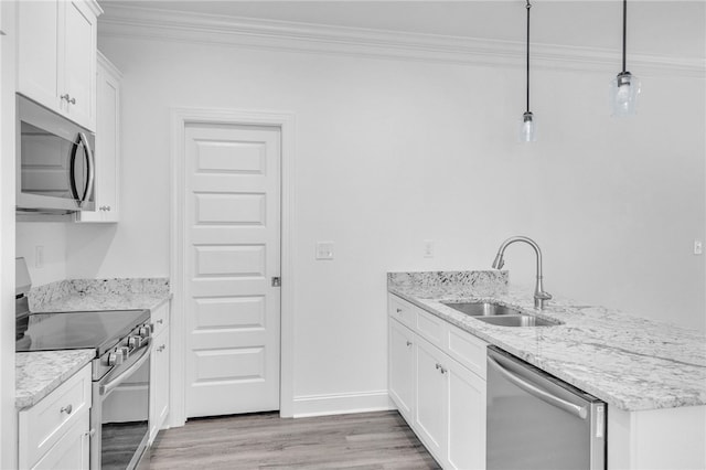 kitchen featuring crown molding, a peninsula, light wood-style floors, a sink, and stainless steel appliances
