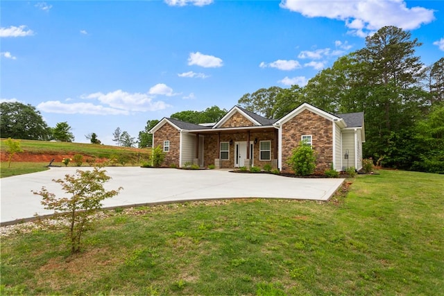 view of front facade featuring covered porch, a front lawn, and stone siding