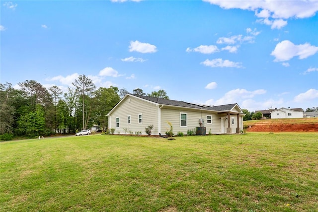 back of property with a yard and central air condition unit