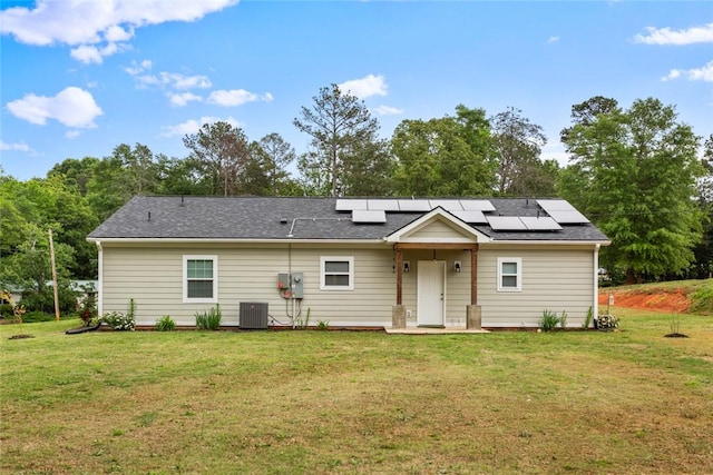view of front facade featuring a front lawn, roof mounted solar panels, and central air condition unit