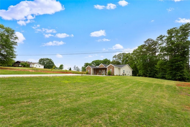 ranch-style home featuring concrete driveway and a front yard