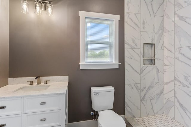 full bathroom with vanity, a tile shower, and toilet