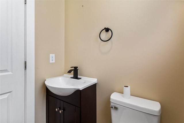 half bathroom featuring vanity and toilet