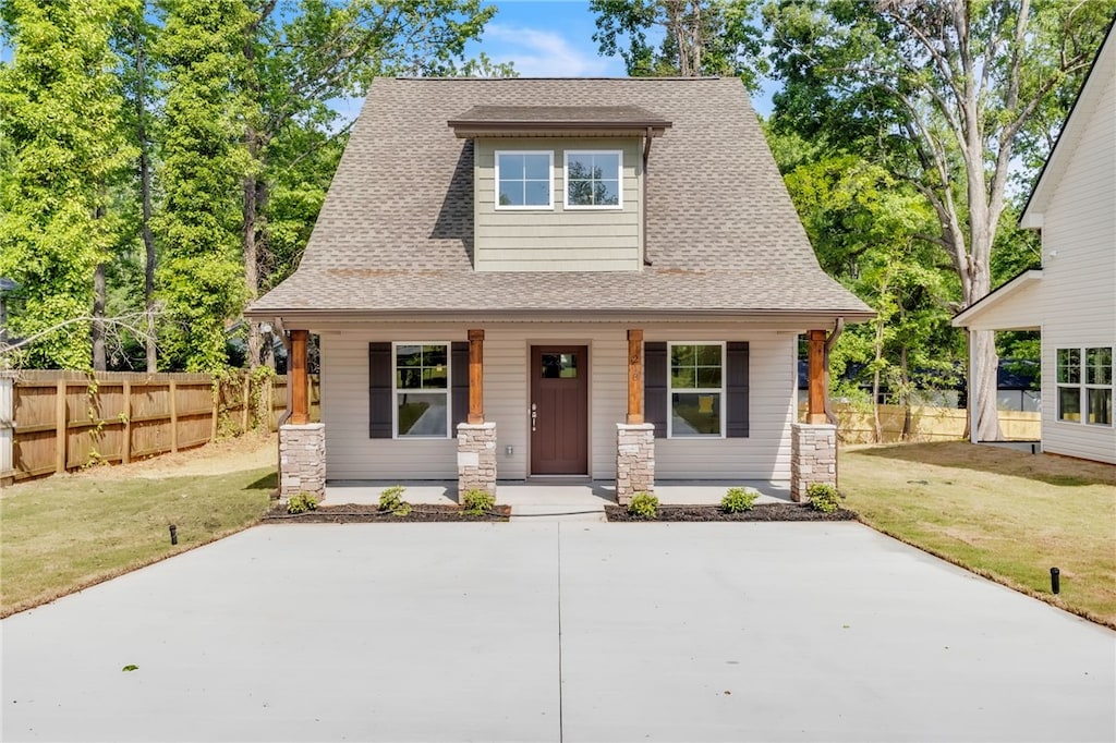 218 Saluda St, Belton, SC 29627 - view of front facade featuring a shingled roof, a front lawn, fence, and covered porch