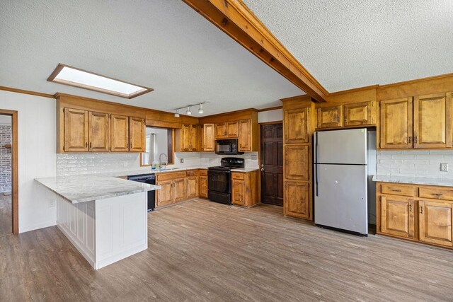 302 Jasmine Dr, Anderson, SC 29625 - kitchen featuring a textured ceiling, brown cabinets, light countertops, a sink, and black appliances