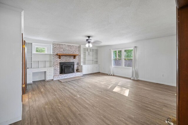 302 Jasmine Dr, Anderson, SC 29625 - unfurnished living room with ceiling fan, a brick fireplace, a textured ceiling, baseboards, and wood finished floors