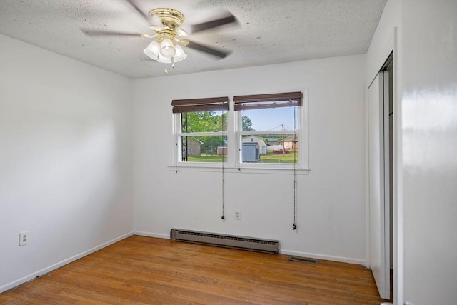 302 Jasmine Dr, Anderson, SC 29625 - unfurnished bedroom featuring a textured ceiling, visible vents, wood finished floors, baseboards, and a baseboard heating unit