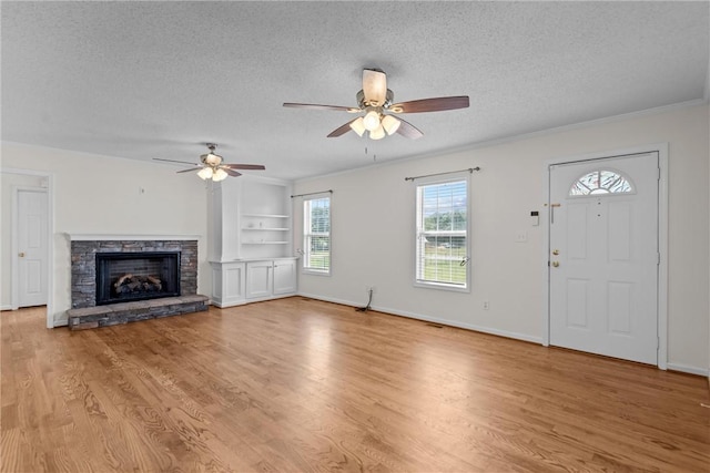 unfurnished living room featuring plenty of natural light, a ceiling fan, and a textured ceiling