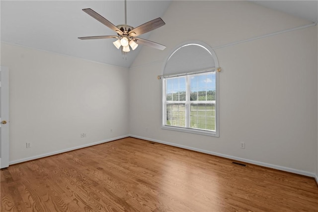 spare room with a ceiling fan, visible vents, wood finished floors, baseboards, and lofted ceiling