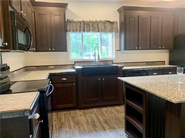 204 Rock Creek Rd, Anderson, SC 29625 - kitchen featuring black appliances, a sink, dark brown cabinetry, light wood-type flooring, and light stone countertops