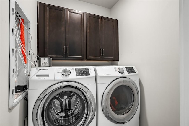 clothes washing area with cabinet space and washer and dryer