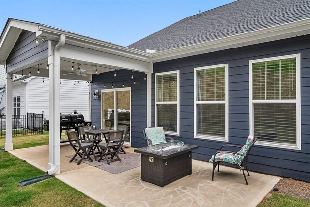 view of patio with ceiling fan, fence, and a fire pit