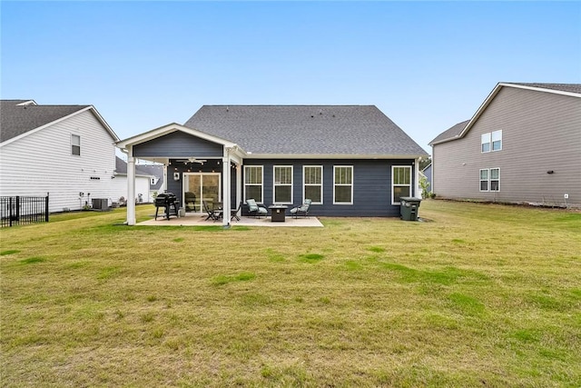 rear view of property featuring fence, a patio area, central air condition unit, a ceiling fan, and a yard