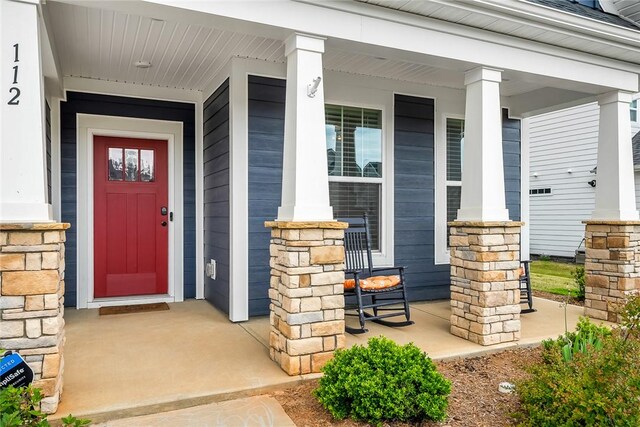 view of exterior entry featuring covered porch