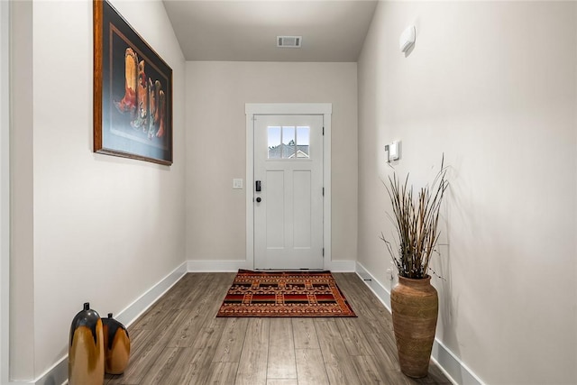 doorway to outside with baseboards, wood finished floors, and visible vents